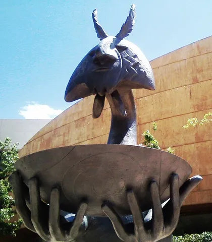 Escultura de bronce de Leonora Carrington: una criatura con orejas de pluma sobre un cuenco sostenido por manos, en Guanajuato, México